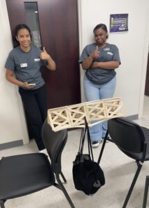 SEED students giving a thumbs up in front of their bridge project