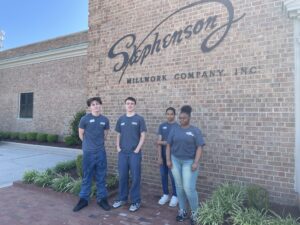 SEED students posing in front of the Stephenson Millworks sign