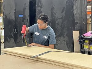 SEED student using a tool to assemble a cabinet