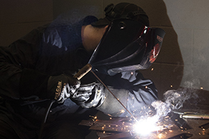 Welding student in face shield stick welding